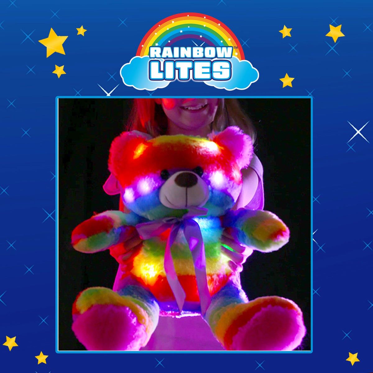 Child holding the brightly glowing rainbow teddy bear in the dark under Rainbow Lites logo.