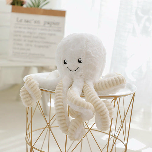 White curly-tentacled octopus plush perched on a wire basket