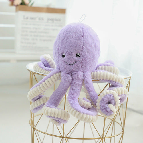 Purple curly-tentacled octopus plush perched on a wire basket