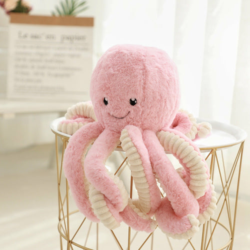 Pink curly-tentacled octopus plush perched on a wire basket