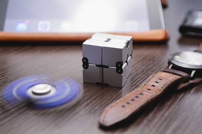 The alloy infinity cube fidget toy in playful arrangement