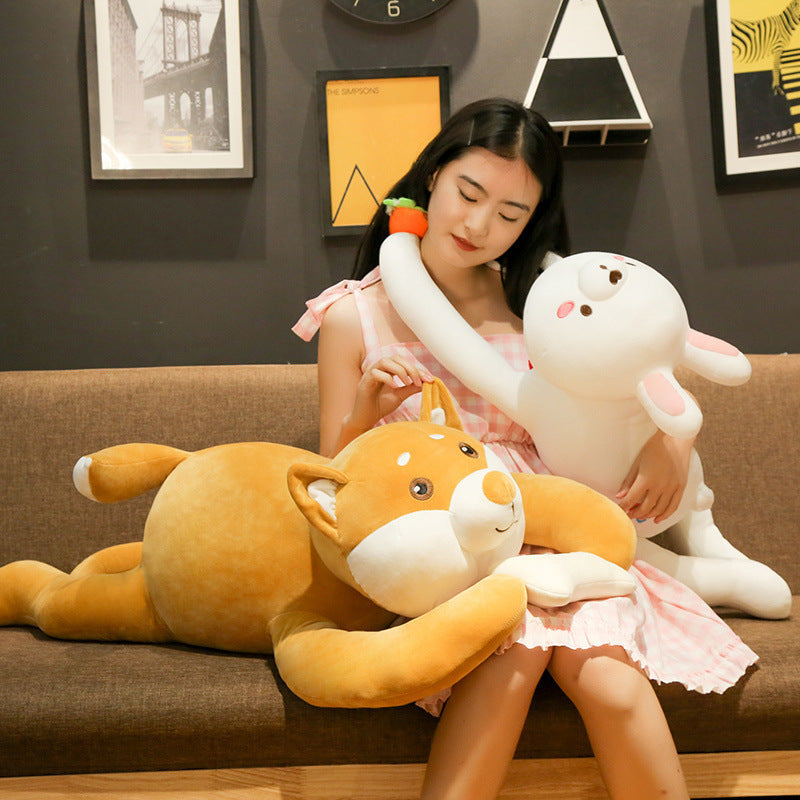 Woman on a couch hugging a giant plush dog and a white rabbit plush