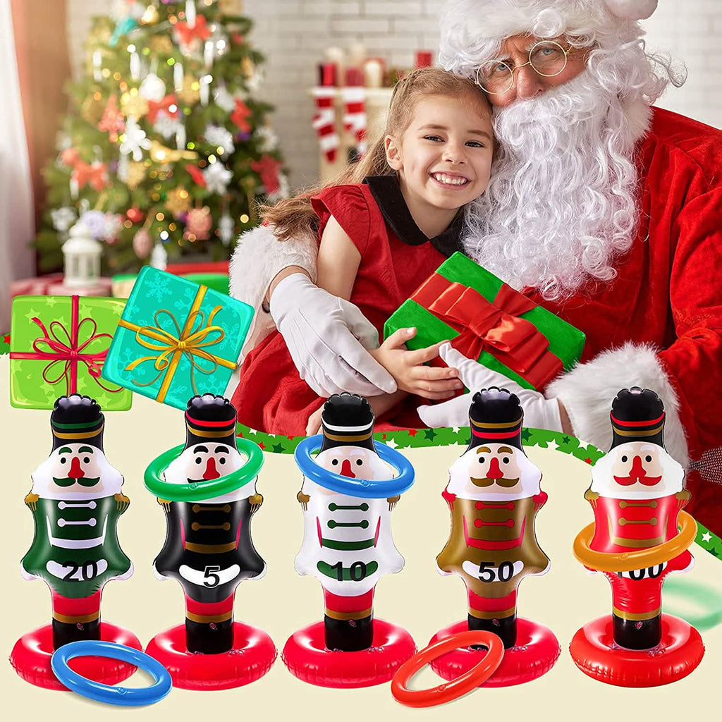 Girl with Santa holding gifts behind five nutcracker ring toss targets.