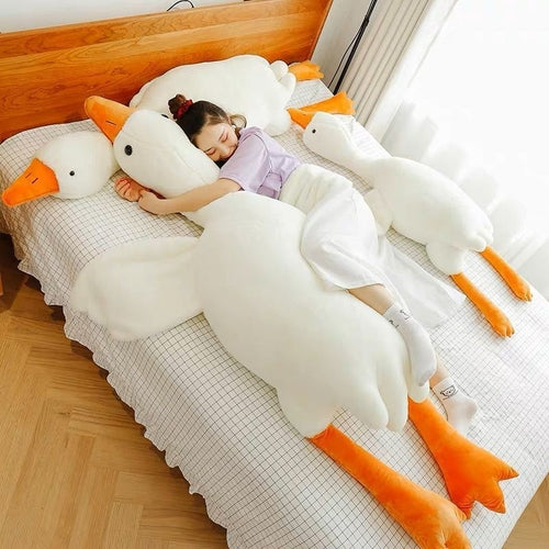 Person reclining among large white goose plush pillows
