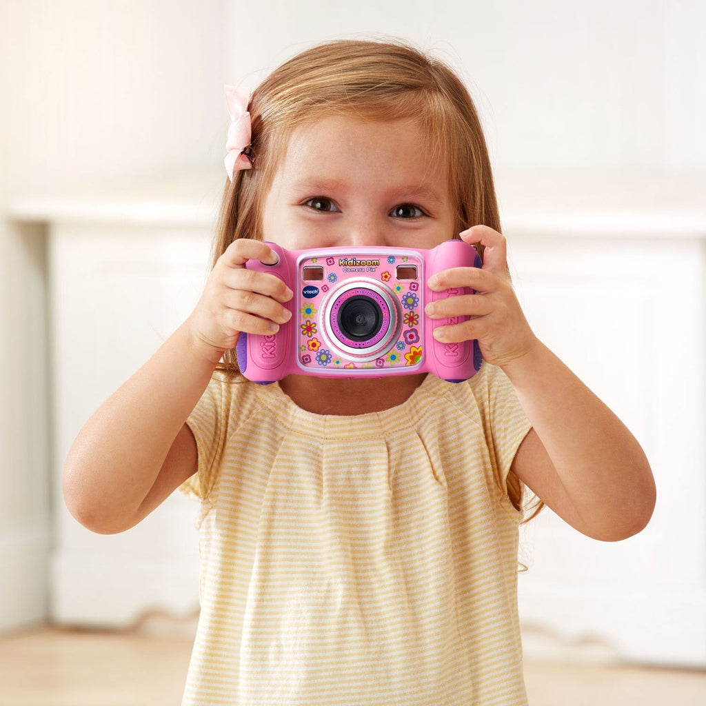 Child holding a pink camera to take a picture