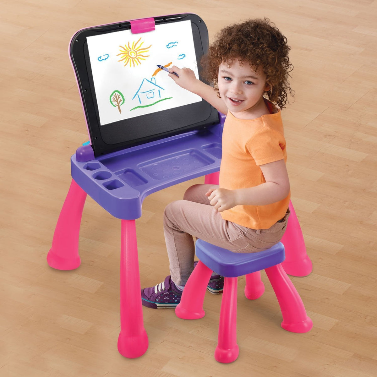 Child using the desk's upright drawing surface