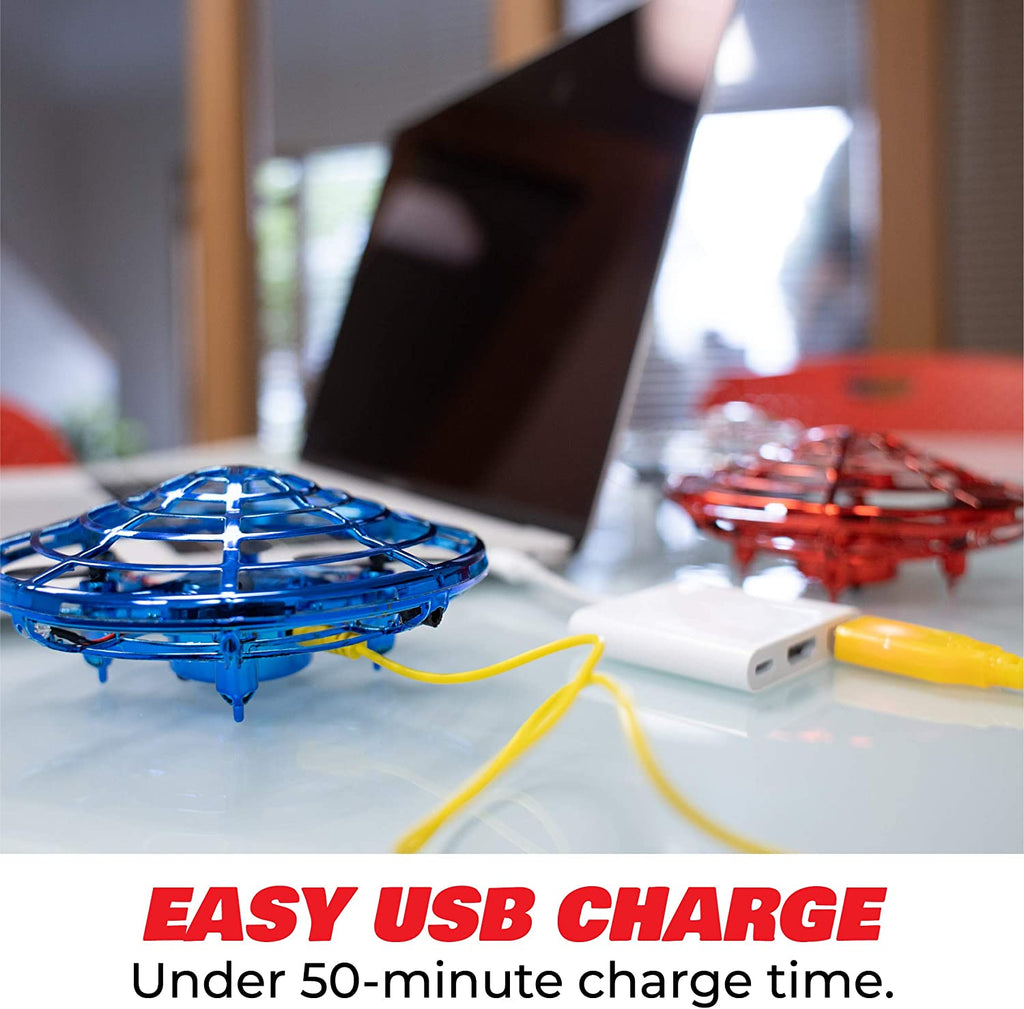 Blue UFO drone beside a laptop and USB charging cable