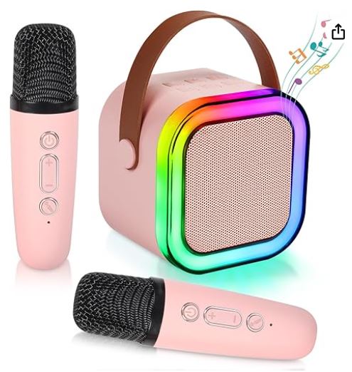 Pink portable karaoke speaker with rainbow LED light ring and two pink wireless microphones.