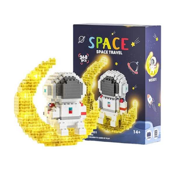 Two completed astronaut moon models in front of the Space Travel packaging.