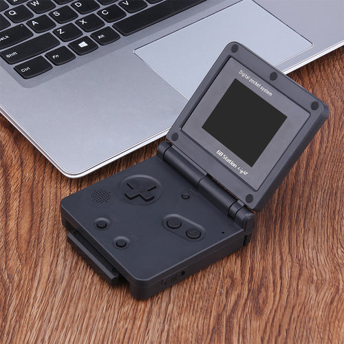 Open folding handheld game player beside a laptop