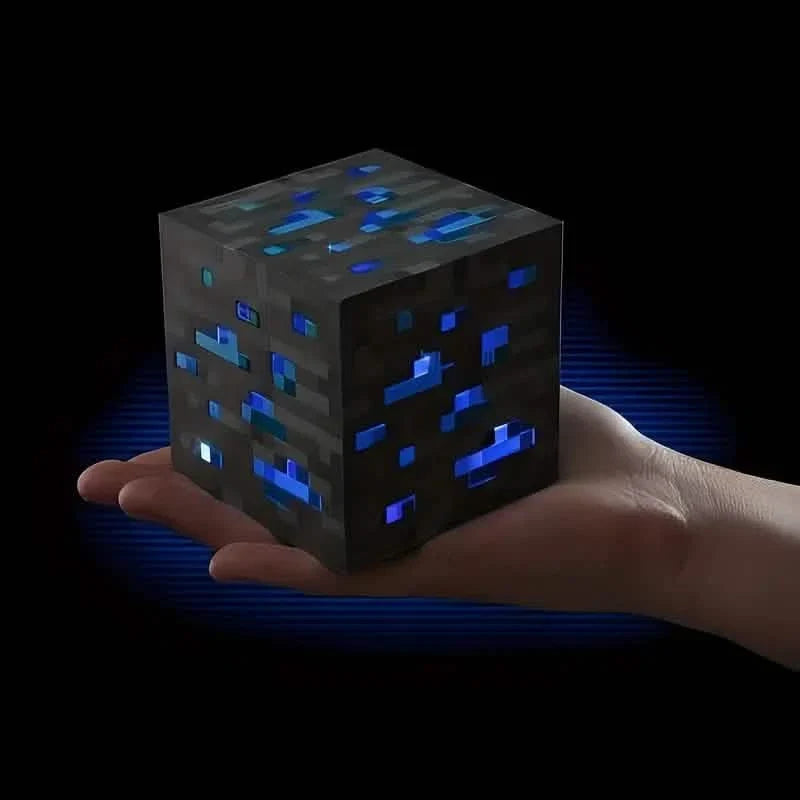 Hand holding a dark blue pixel ore block light with glowing blue crystals.